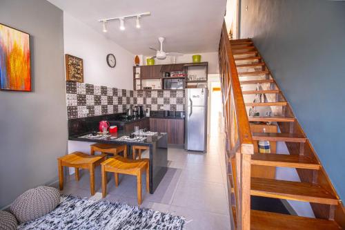 a kitchen with a table and chairs and a staircase at Apto Novo Duplex em Juqhey in Juquei