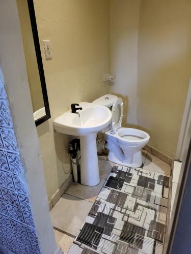 a bathroom with a toilet and a sink at THK Properties in Pretoria