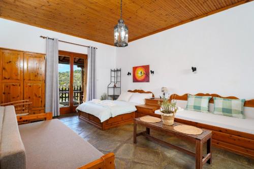 a living room with two beds and a table at Giola Bungalows Sirines in Astris