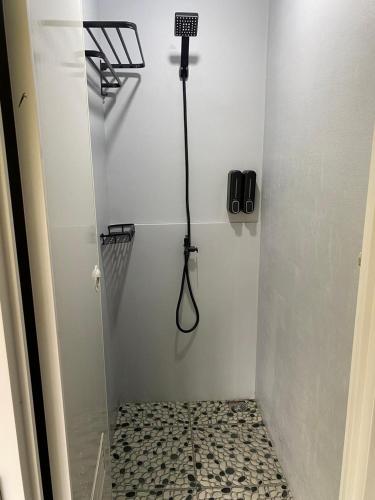 a bathroom with a shower with a phone on the wall at corak alam glamping in Tangkubanperahu