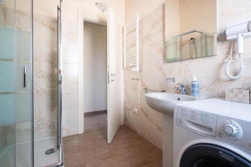 a bathroom with a washing machine and a sink at PinetoAlba Country House in Scerne