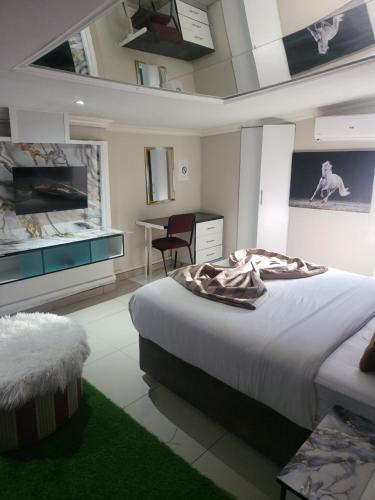 a bedroom with a large bed and a desk and a table at THK Properties in Pretoria