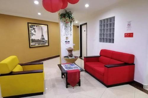 a living room with a red couch and a table at Puteri Ampang Hotel in Ampang