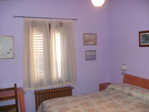 a bedroom with a bed and a window at Hotel Bristol in Fiumalbo