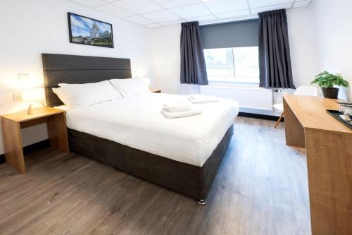 a bedroom with a large bed with a desk and a window at Guest Rooms at Lancaster University in Lancaster