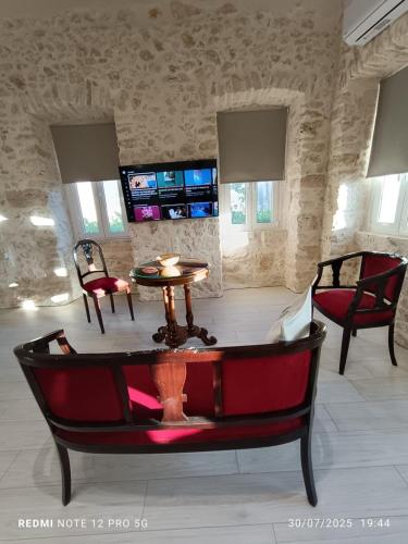 a living room with a table and two chairs at Suites-Xenonas "Alexandra's Coffee House" in Volímai