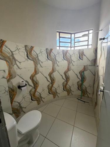 a bathroom with a painting on the wall at Pousada Nova Betânia in Mossoró