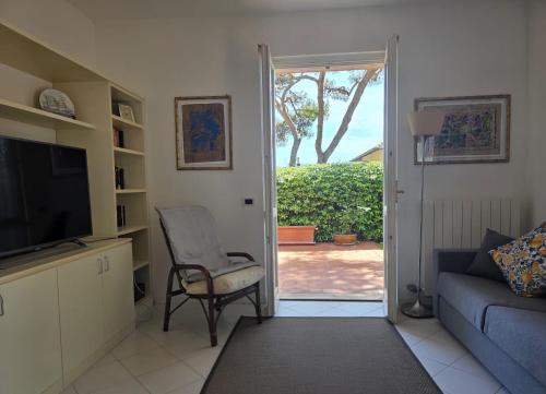 a living room with a couch and a chair and a sliding door at Casa Limone by Affitti Brevi Liguria in Borgio Verezzi