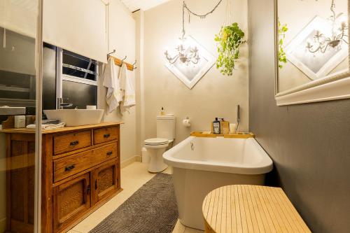 a bathroom with a tub and a sink and a toilet at Lagoon Views in Knysna