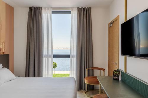 a hotel room with a bed and a large window at B&B HOTEL Venezia Laguna in Venice
