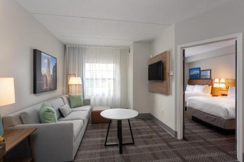 a hotel room with a couch and a bed at Staybridge Suites Buffalo by IHG in Buffalo