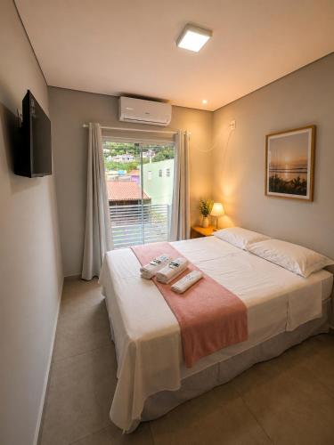 a bedroom with a large bed and a window at GH Canal da Barra in Florianópolis