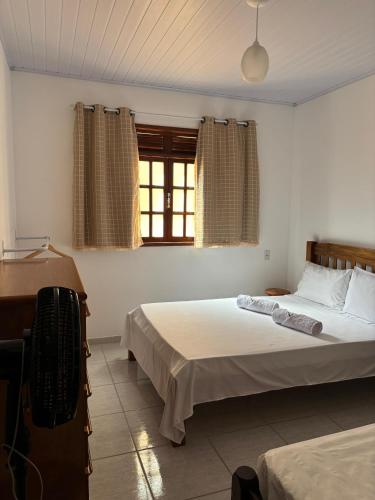a bedroom with two beds and a window at Casa Zago 2 in Santa Maria Madalena