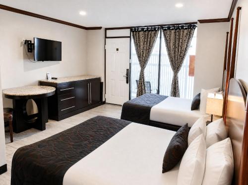 a hotel room with two beds and a desk at Beachside Resort in Wildwood
