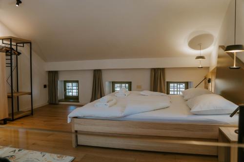 a bedroom with a large bed with white sheets and pillows at Hiša Liza in Kobarid
