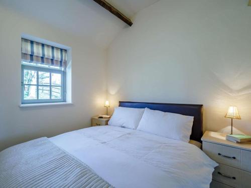 a bedroom with a bed with white sheets and a window at 1 Bed in Hexham oc-82472 in Hexham