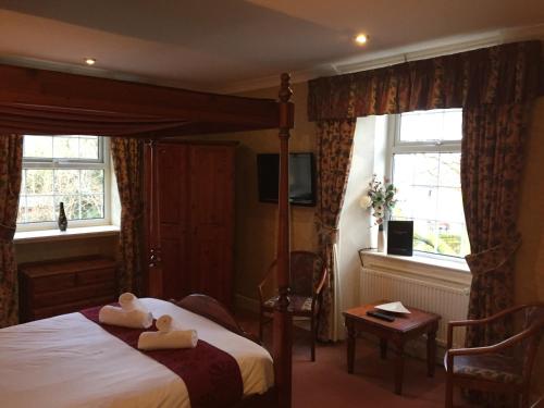 a bedroom with a bed with two towels on it at Healey House Hotel in Batley