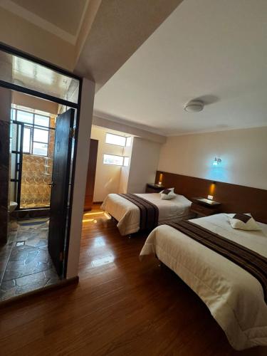 a hotel room with two beds and a window at Asian House in Uyuni