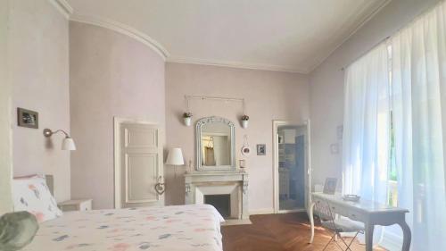 a bedroom with a bed and a mirror and a desk at Domaine de ferrabouc in Mas-Saintes-Puelles