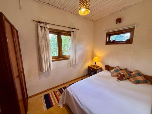 a bedroom with a white bed and a window at Casa Pequi in Alexânia