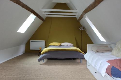 a bedroom with two beds in a attic at La maison bleue des Pyrénées in Argut-Dessous
