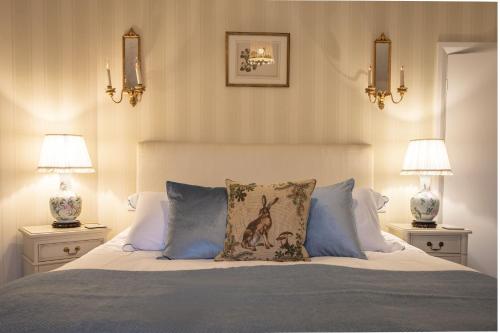 a bedroom with a bed with blue pillows and two lamps at Virginia Cottage 4 in York