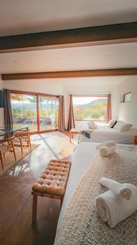 a hotel room with two beds and a balcony at Hotel Patagonia House in Coihaique