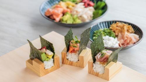 four wooden boxes of sushi on a table with bowls of food at ANA Crowne Plaza Sapporo by IHG in Sapporo