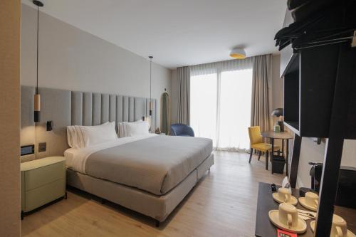 a hotel room with a large bed and a table at Grand Brizo Bel Air in Buenos Aires