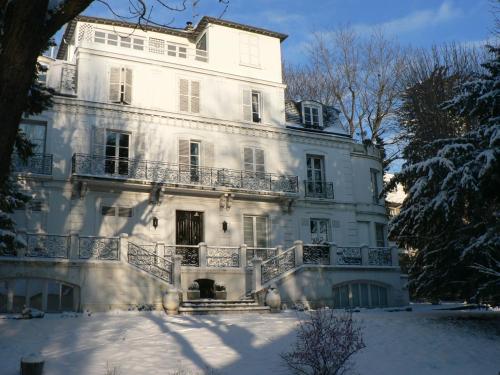 聖克勞德的住宿－尤金妮婭住宿加早餐旅館，一座大白房子,地面上积雪