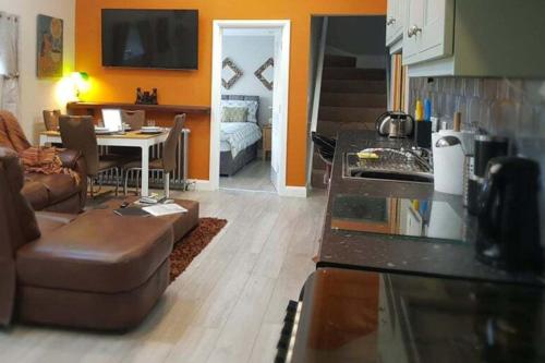 a kitchen and living room with a couch and a table at Magical 3-Bed Stone Built Cottage - Sleeps 6 in Ballynahinch