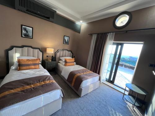 a hotel room with two beds and a large window at Crixus Hotels Sarsing in Sarsing