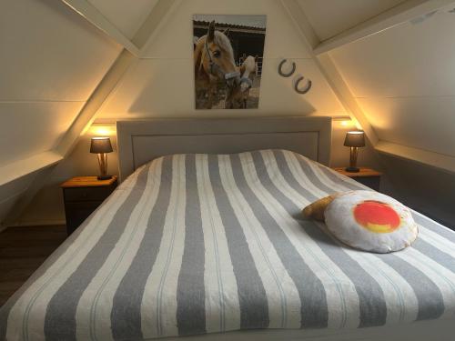 a bedroom with a bed with a horse picture on the wall at Landelijk Hijken in Hijken