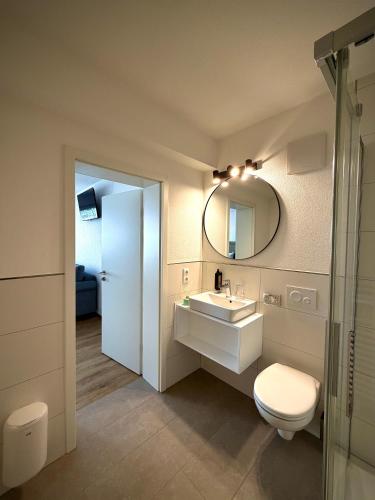 a bathroom with a toilet and a sink and a mirror at Heimatblick Fulda in Fulda