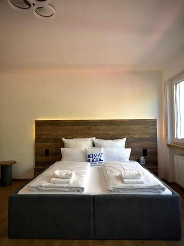 a bedroom with a large bed with a wooden headboard at Heimatblick Fulda in Fulda