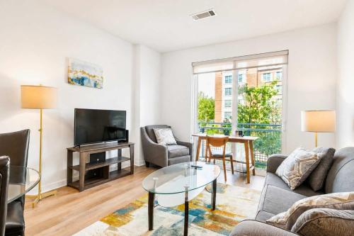 a living room with a couch and a tv at Modern Apt Downtown with Pool in Stamford