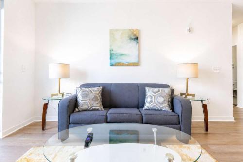 a living room with a blue couch and two tables at Modern Apt Downtown with Pool in Stamford