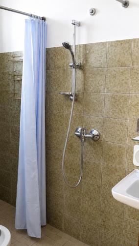 a shower with a shower curtain in a bathroom at Hotel Podgora Nuova Gestione in Rimini