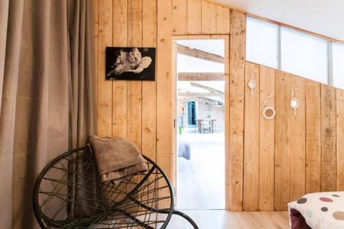 Cette chambre est dotée d'une chaise et de murs en bois. dans l'établissement La Chicorée, à Annoeullin