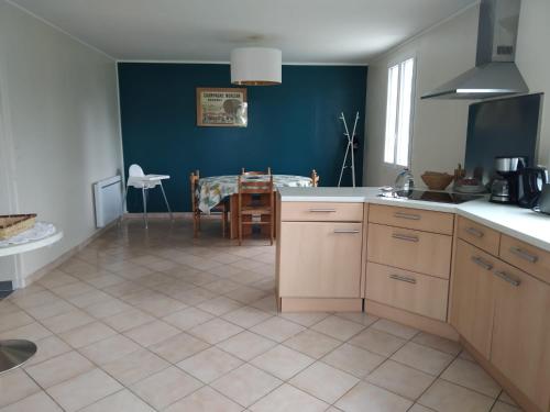 a kitchen with a table and a dining room at La Bourgandie in Englesqueville-la-Percée