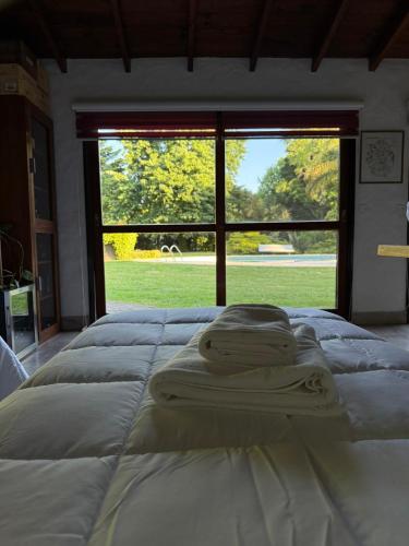 two beds in a room with a large window at LPR EZE Airport in La Unión