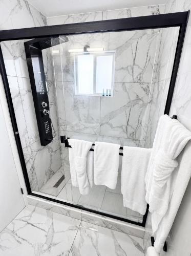 a bathroom with a shower with white towels at Paradise Inn in Wildwood