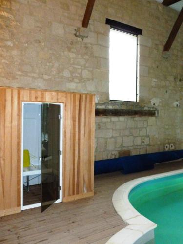 a room with a swimming pool and a window at La chambre au Château in Pernant