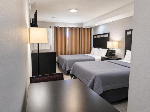 a hotel room with two beds and a table at Paradise Inn in Wildwood