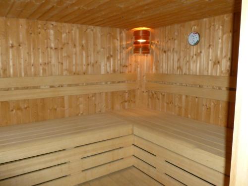 a sauna with wood paneling and a clock at La chambre au Château in Pernant