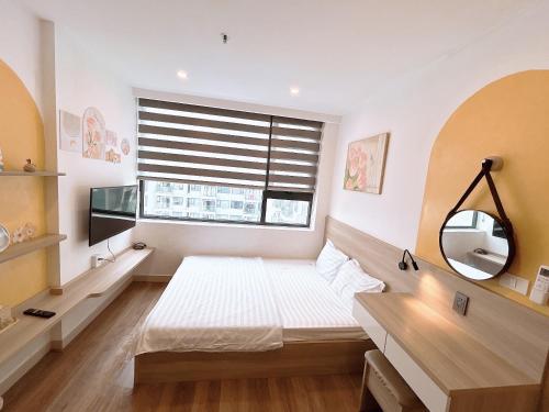 a bedroom with a bed and a window with a mirror at Minh Anh Apartment 5 in Thôn Văn Dương