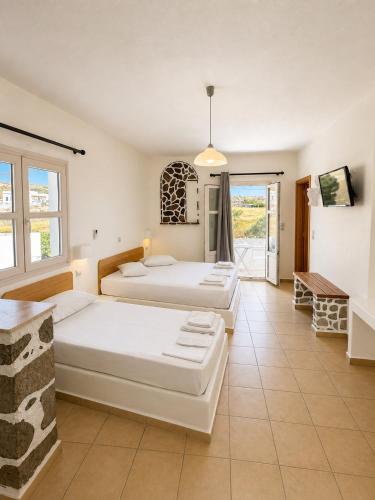 a bedroom with two beds and a balcony at Filoxenia Apartments in Adamantas