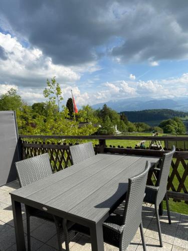 a wooden table and chairs on a balcony with a view at Panorama-Chalet Unterbach in Hinwil