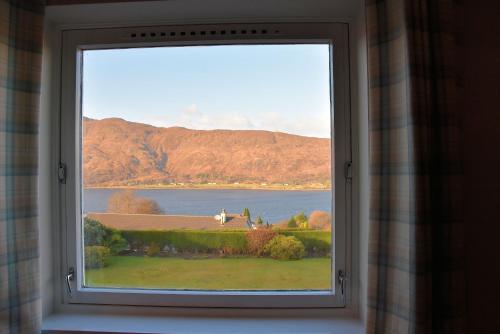 a window with a view of a lake and mountains at Lochview House in Fort William