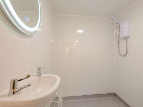 a white bathroom with a sink and a shower at 1 Bed in Conwy oc-79464 in Conwy